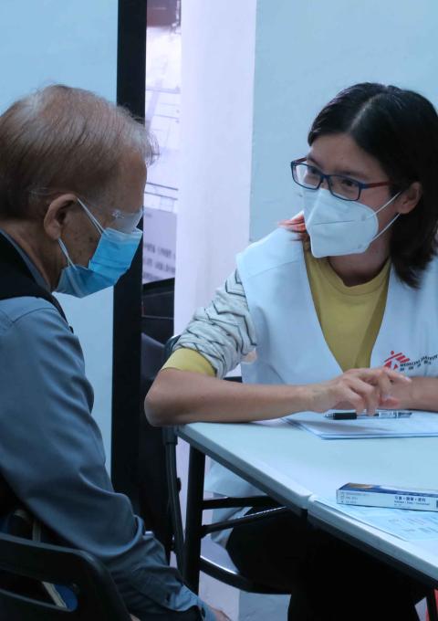 A local man speaks with MSF's Dr Joyce Ching during a COVID-19 vaccination consultation. Hong Kong, March 2022.