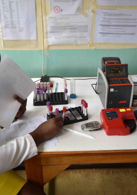 Clinician preparing samples for a point-of-care CD4 testing machine, Homa Bay County teaching and referral hospital, Kenya