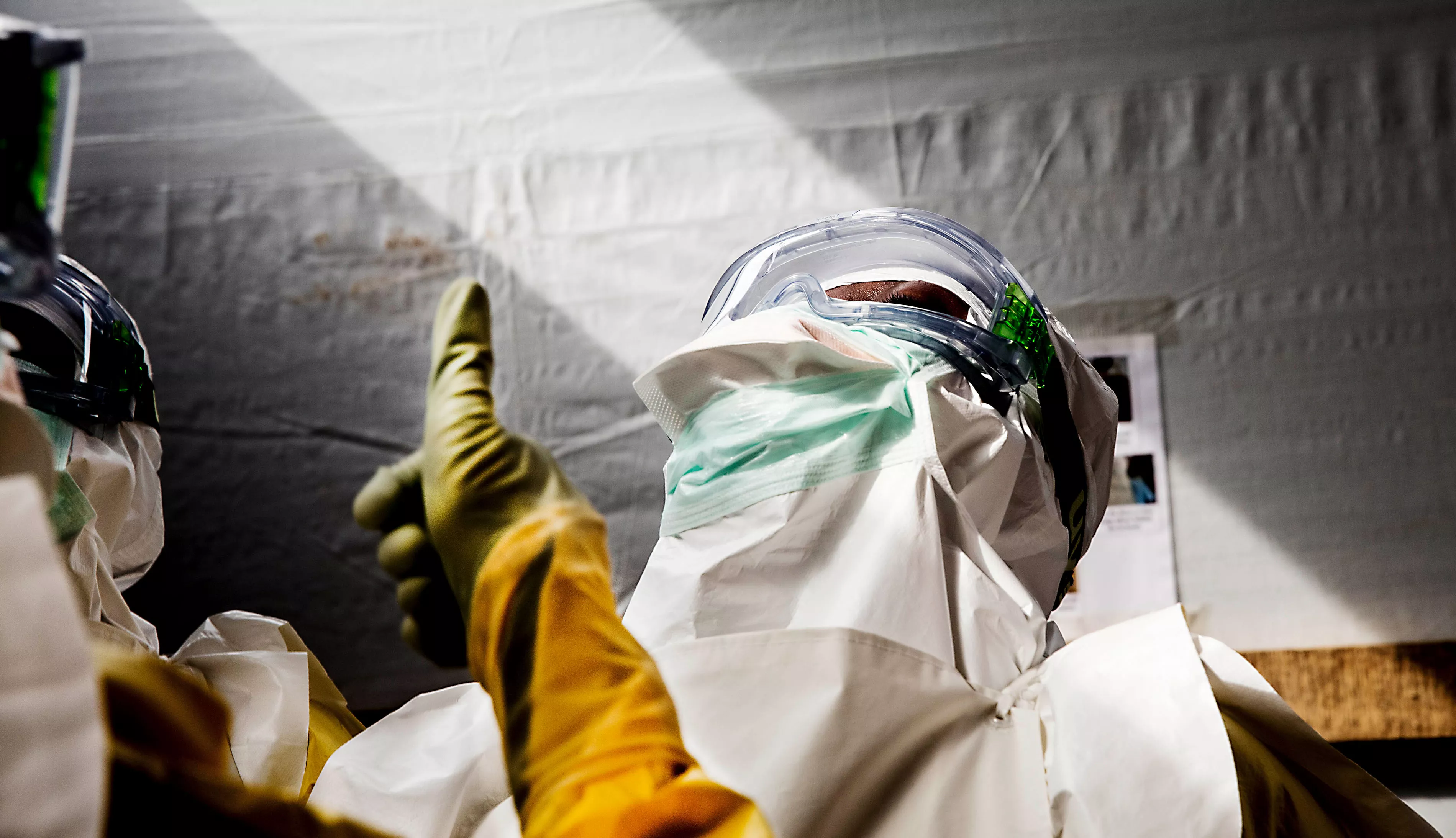 Nurses check each other's PPE as the prepare to enter the high-risk zone in MSF's Ebola treatment center in Sierra Leone.