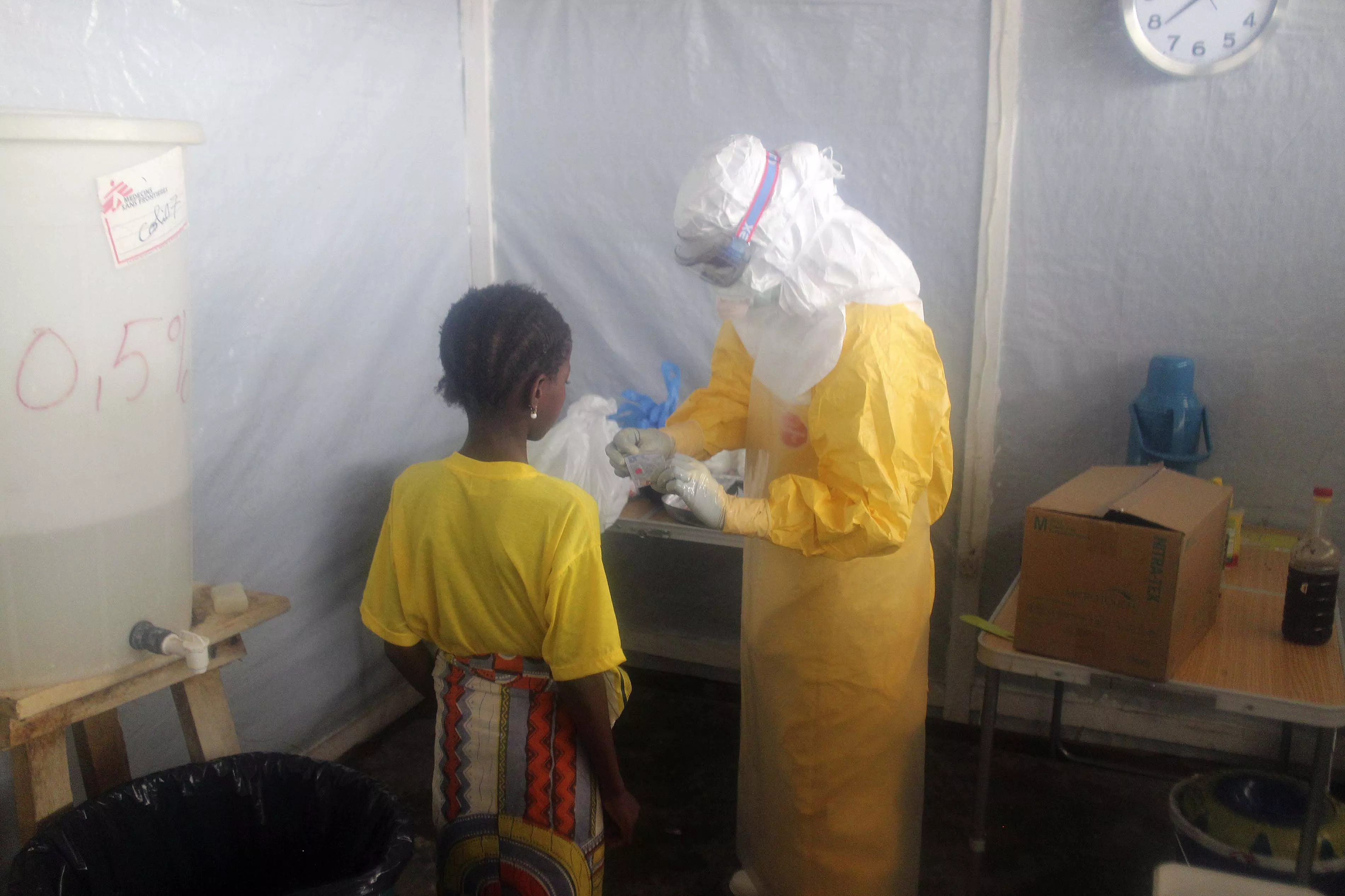 A nurse gives pain killers to a 12-years old girl staying in the Ebola isolation ward.