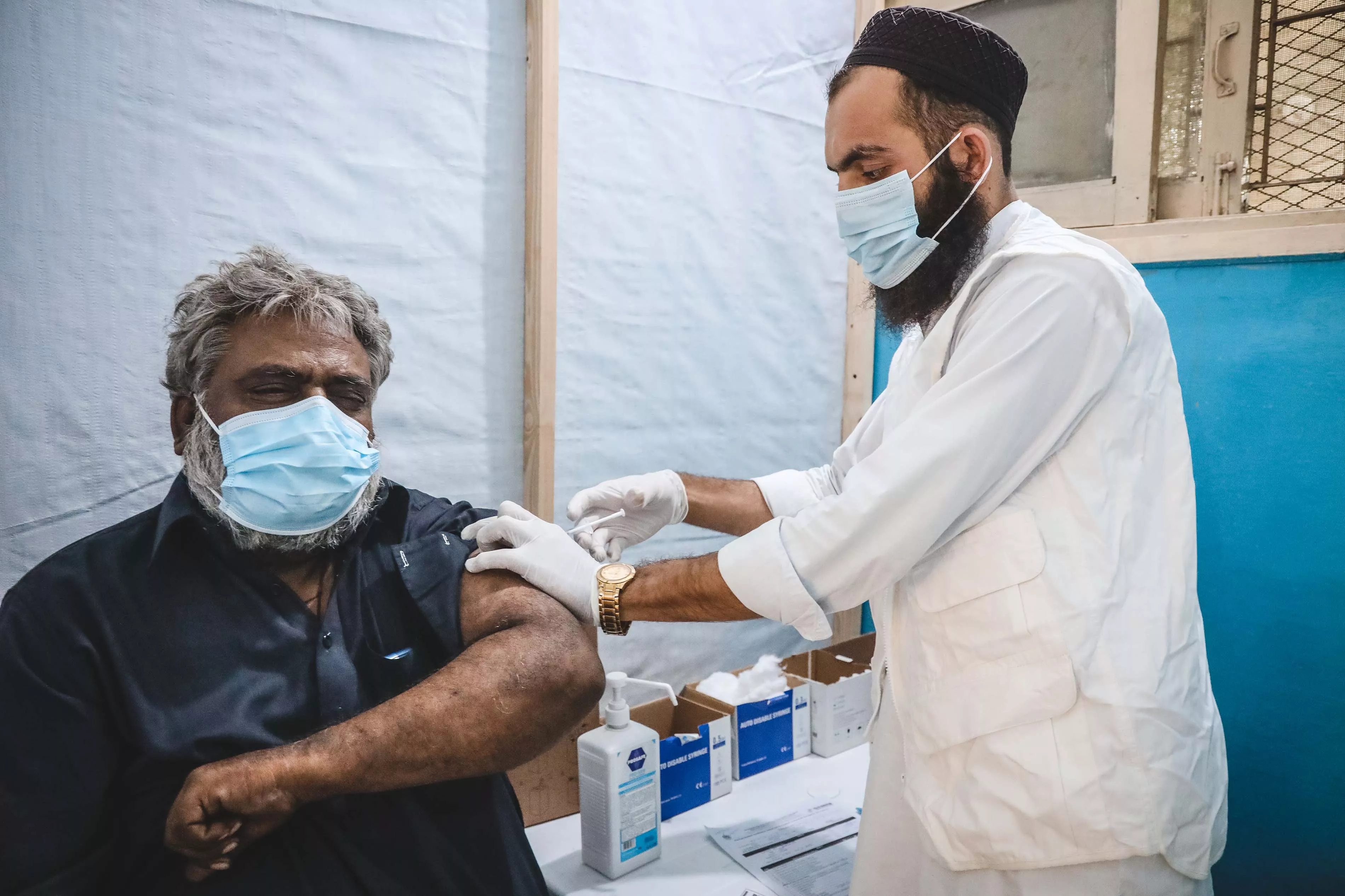 An MSF nurse administering the COVID-19 vaccine to Muhammad Sarwar.