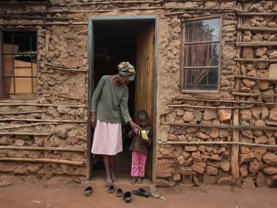Winile stands outside her house in the Manzini region of Swaziland