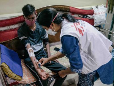 Prachi, an MSF nurse, performs a pre-infusion procedure for Chetan, who lives with DR-TB.