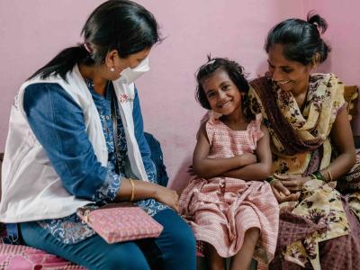 Vaishnavi, a 7-year-old DRTB (Drug Resistant​ Tuberculosis) patient interacts with Prachi, an MSF nurse as her mother Vishaka holds her.