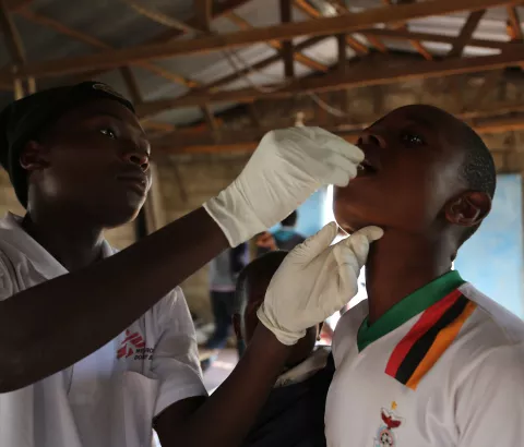 A member of the MSF vaccination team provides a single dose of oral cholera vaccine to a boy at True Vine Church, one of the 15 sites used by MSF in the district of Kanyama during a massive vaccination campaign in Lusaka