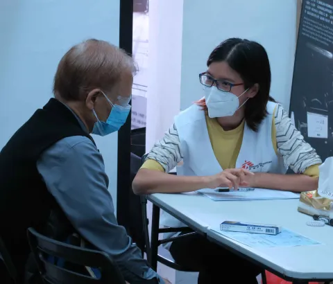 A local man speaks with MSF's Dr Joyce Ching during a COVID-19 vaccination consultation. Hong Kong, March 2022.